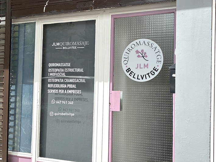 ntrada a la nueva consulta de masajes con el cartel informativo y vinilos decorativos en el cristal de la puerta.